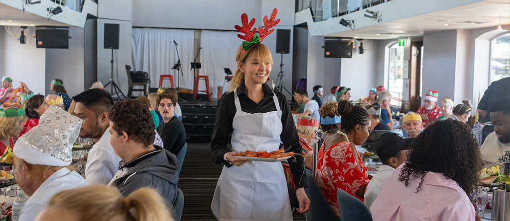 Crew of Sydney Showboat in Christmas attire, serving guests onboard on Christmas Day