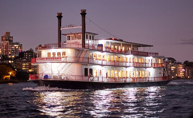 The authentic paddlewheeler floats on the cruising waters with views of the city skyline.